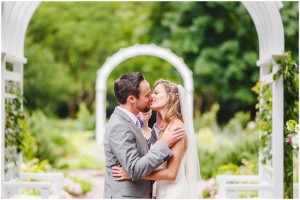 A kiss under the arbor in the Grace Arents Garden at Sarah and Simon’s Lewis Ginter Botanical Garden Wedding. Photos by Steven and Lily photography