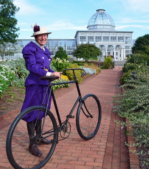 Female cyclist in purple outfit in front of the Conservatory