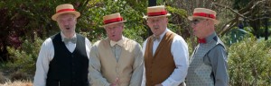 Barbershop Quartet dressed in vests and straw hats with ribbon