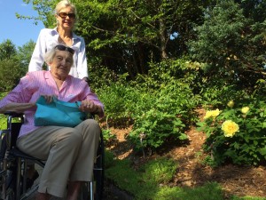 Therese Wilson (seated) and Caroline McLean posing next to a yellow peony – Peonia lactiflora ‘Mister Ed’.