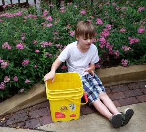 A boy taking a break from weeding the Children's Garden. 