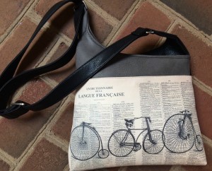 A gray and black messenger bag with bike motif converts to a back pack.