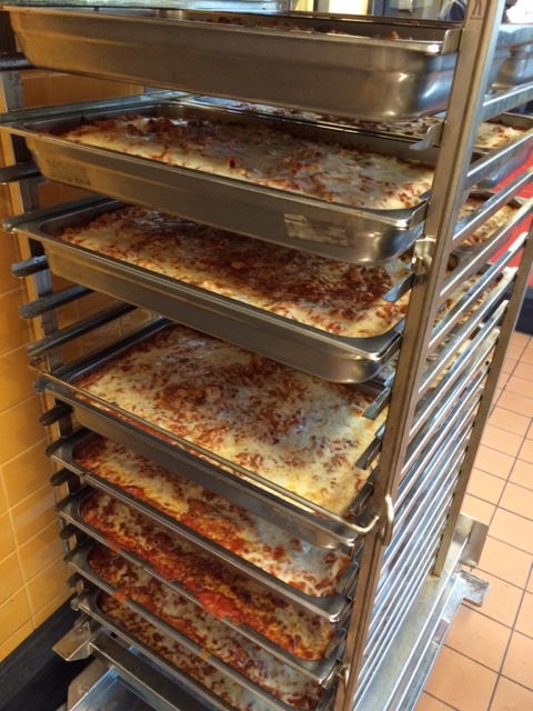  Almost 900 servings of Eggplant Zucchini casserole cool on racks in the Community Kitchen.