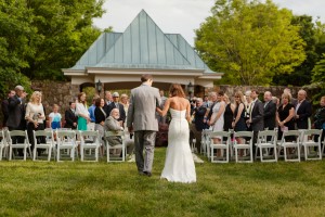 Bride walks down the isle at an outdoor wedding. Image by Katelyn James Photography