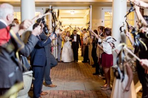 A newly married couple exits the Robins Visitor Center through a tunnel of streamers. Image by Mary Otanez Photography.