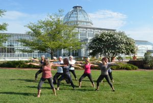 Warrior Pose yoga class in the rose garden