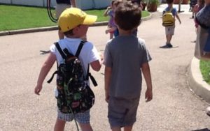 two friends at camp walking toward the conservatory