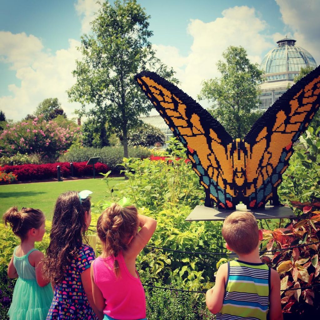 Kids enjoying the Eastern Swallowtail Butterfly LEGO brick sculpture from Nature Connects: Art with LEGO Bricks. Photo by @carollane1111