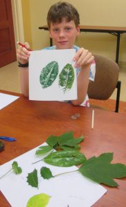 riley showing off his print made during camp