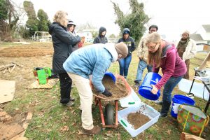 urban gardeners help Jessica transfer soil to containers