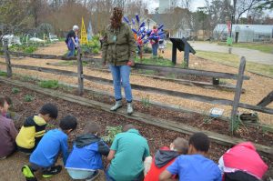 Tarneshia Evans instructing kids on how to plant their dill seeds.