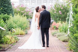 Couple kisses at their outdoor wedding at Lewis Ginter Botanical Garden. Image by Karin Nichole Photography.