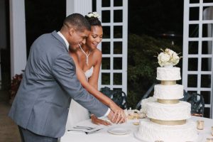 Cutting wedding cake at outdoor wedding at Bloemendaal House. Image by David Abel Photography.