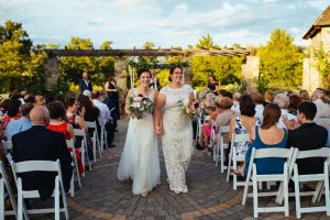 Couple walking down isle of Rose Garden ceremony. Image by A Lovely Photo.