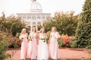 Bridesmaids walk through the Central Garden during an outdoor wedding. Image by J&D Photography.