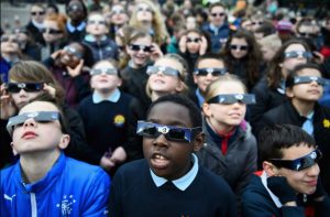 Children watching the solar eclipse wearing protective shades. Image by Mark Margolis.