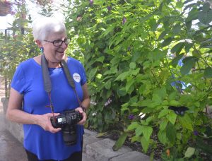 photo of photographer Jeanne Schlesinger smiling next to a butterfly
