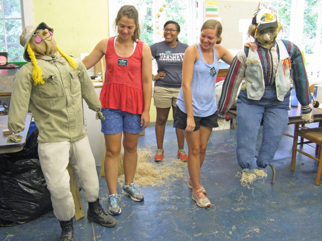 Intern Lia Bazemore with scarecrows