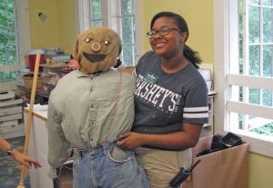 intern Lia Bazemore with her scarecrow