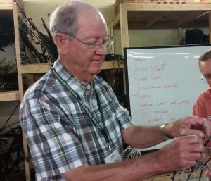 Man works on light form.