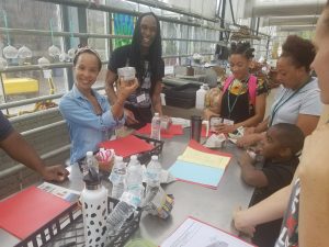 Elisa Bennett Holding up a plant in the greenhouse