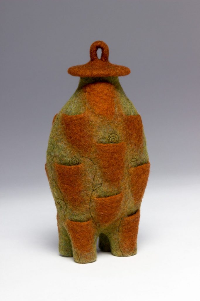 Wool sculpture in rust and chartreuse.
