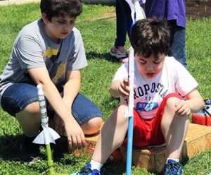 Image of two boys preparing model rockets.