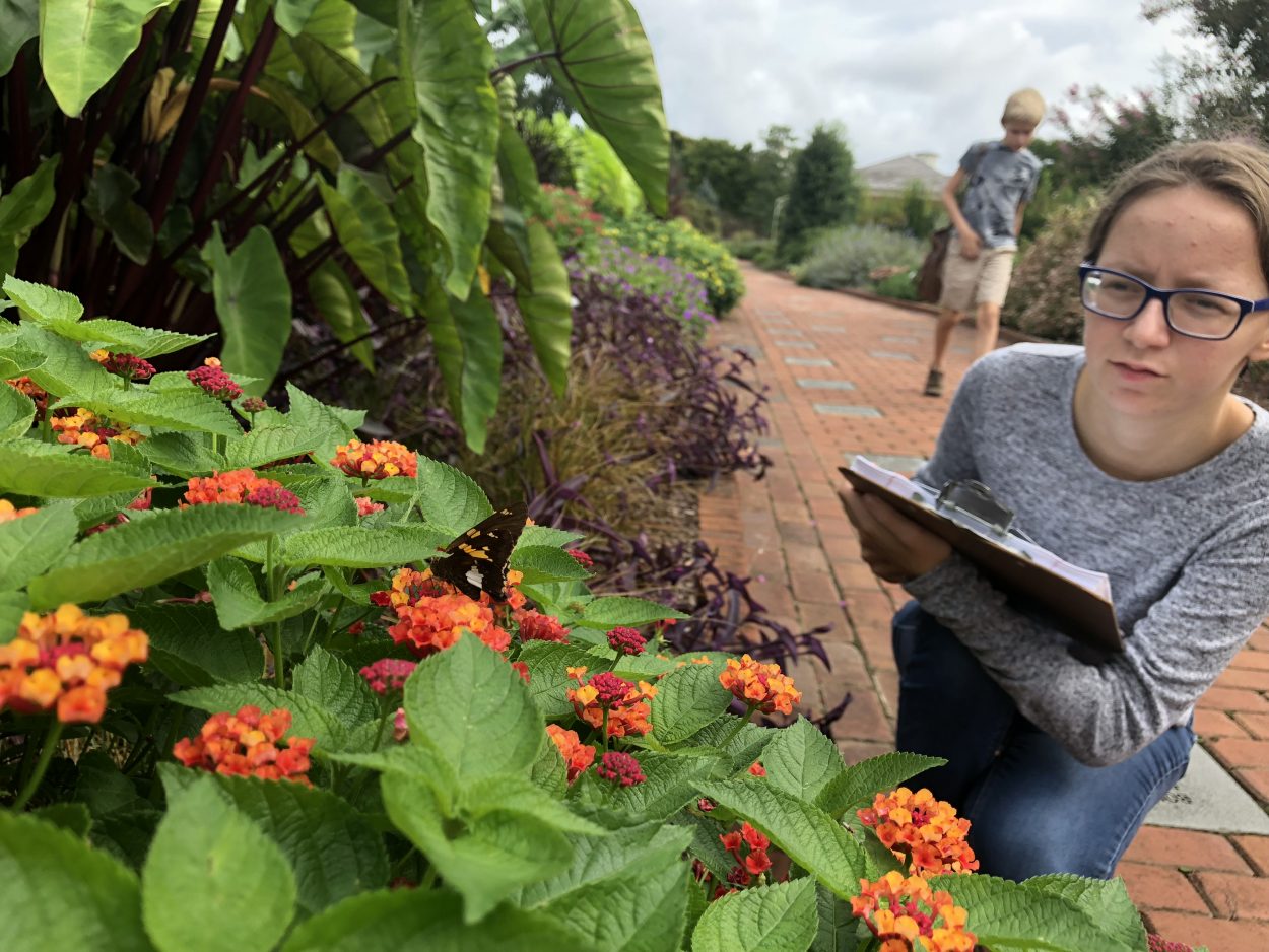 Citizen Scientist student takes notes in a garden.