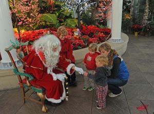 santa handing candy to a child at Merry Mondays