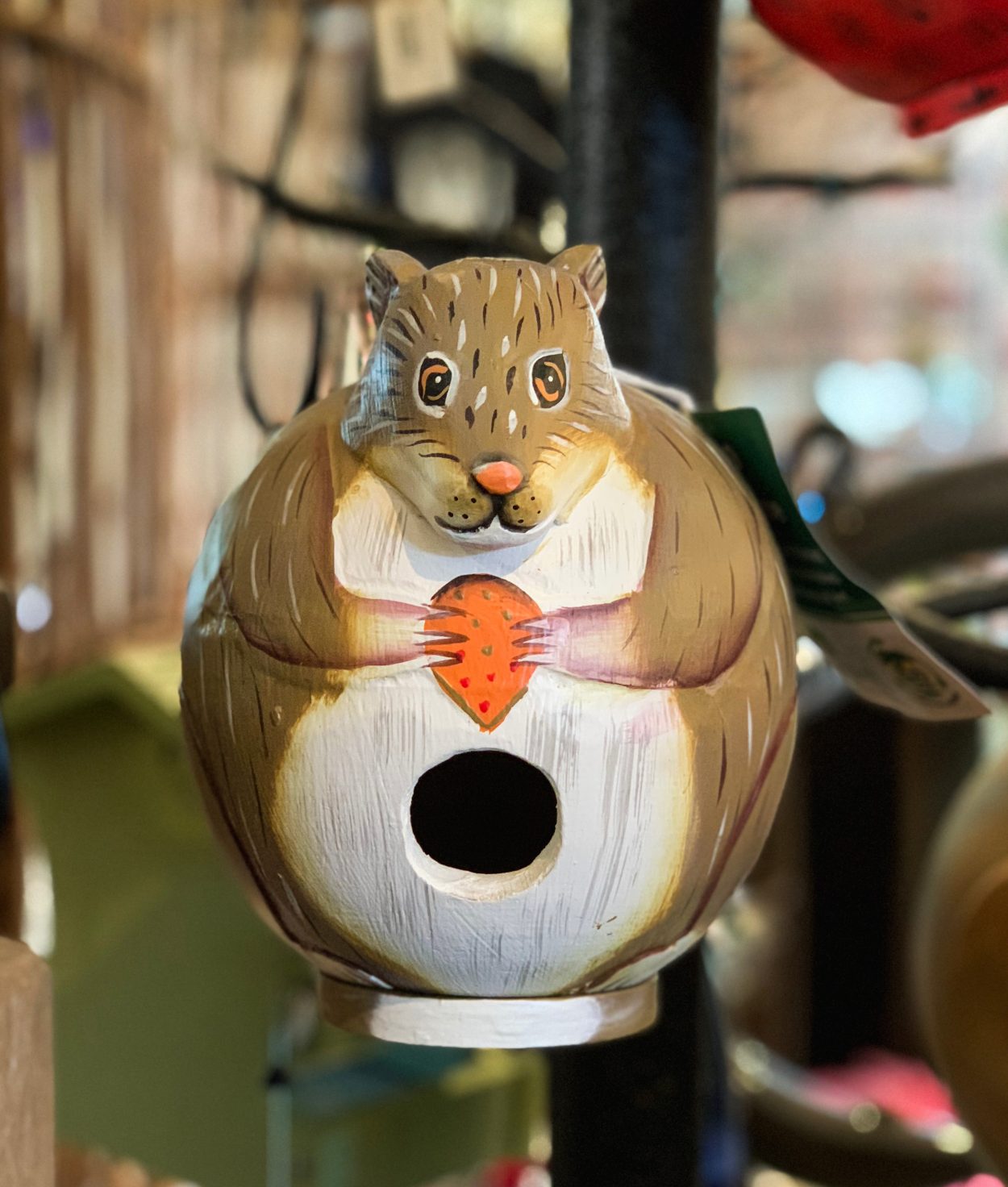 Painted squirrel bird house, with entrance hole in belly.