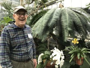 John Popenoe laughing with a cicad plant in the background
