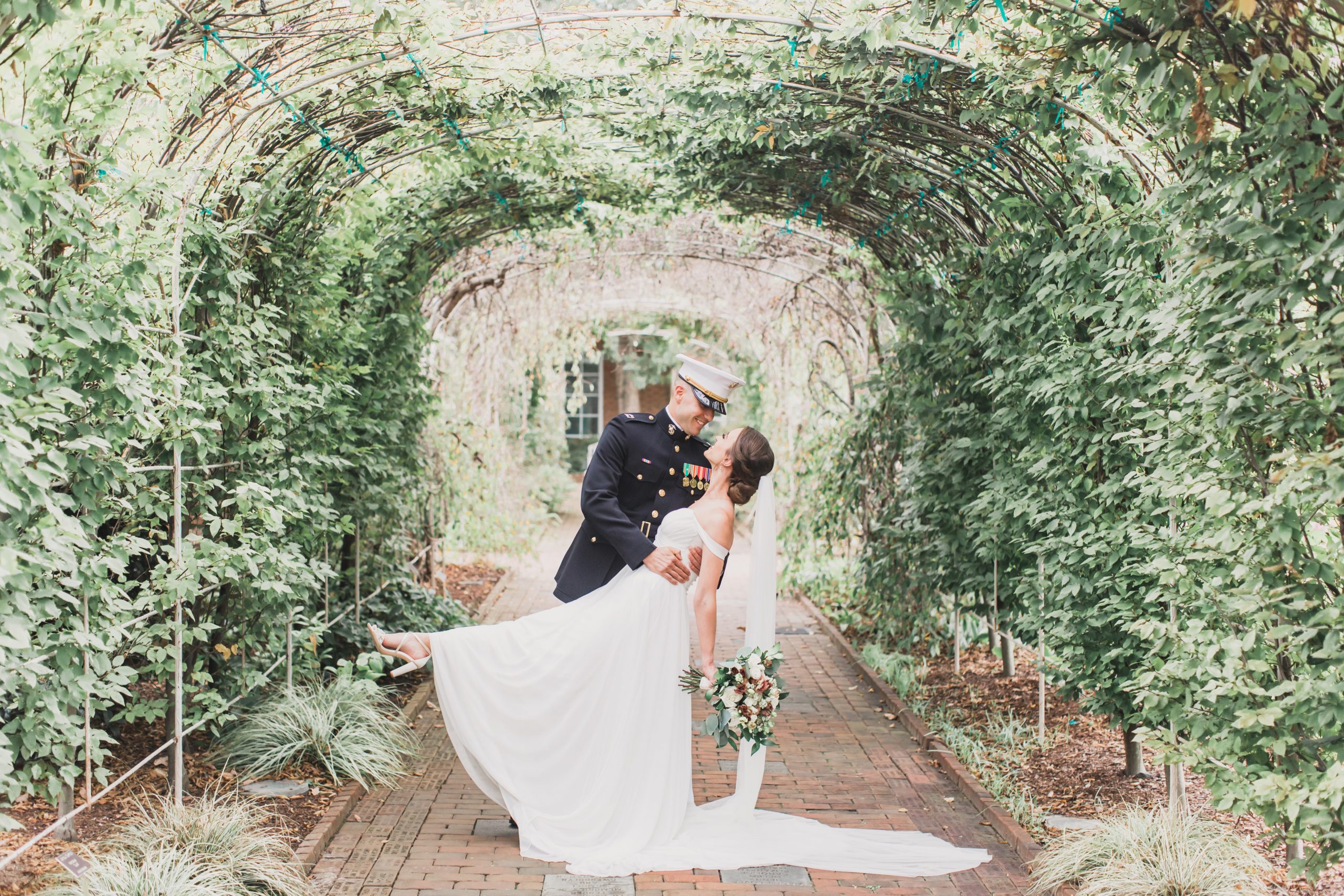 A Marine and bride in the tunnel of trees kissing -- just one of the perks of choosing our wedding venues