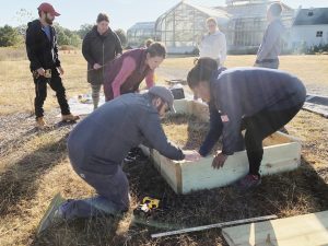 Volunteers install raised beds that Afghan women refugees will use to plant herbs and vegetables