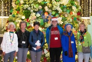 Thank you Volunteers !Here Garden Guides pose in front of the holiday tree. Image by Harlow Chandler