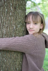 Girl hugging tree for love a tree day. Image by Mitra Bryant