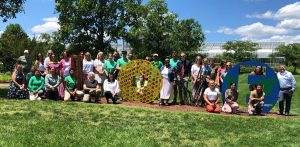 The staff of Lewis Ginter Botanical Garden standing in front of the LOVE letters sign and the Conservatory