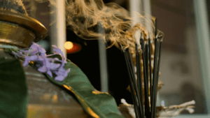 Burning incense surrounded by leaves.